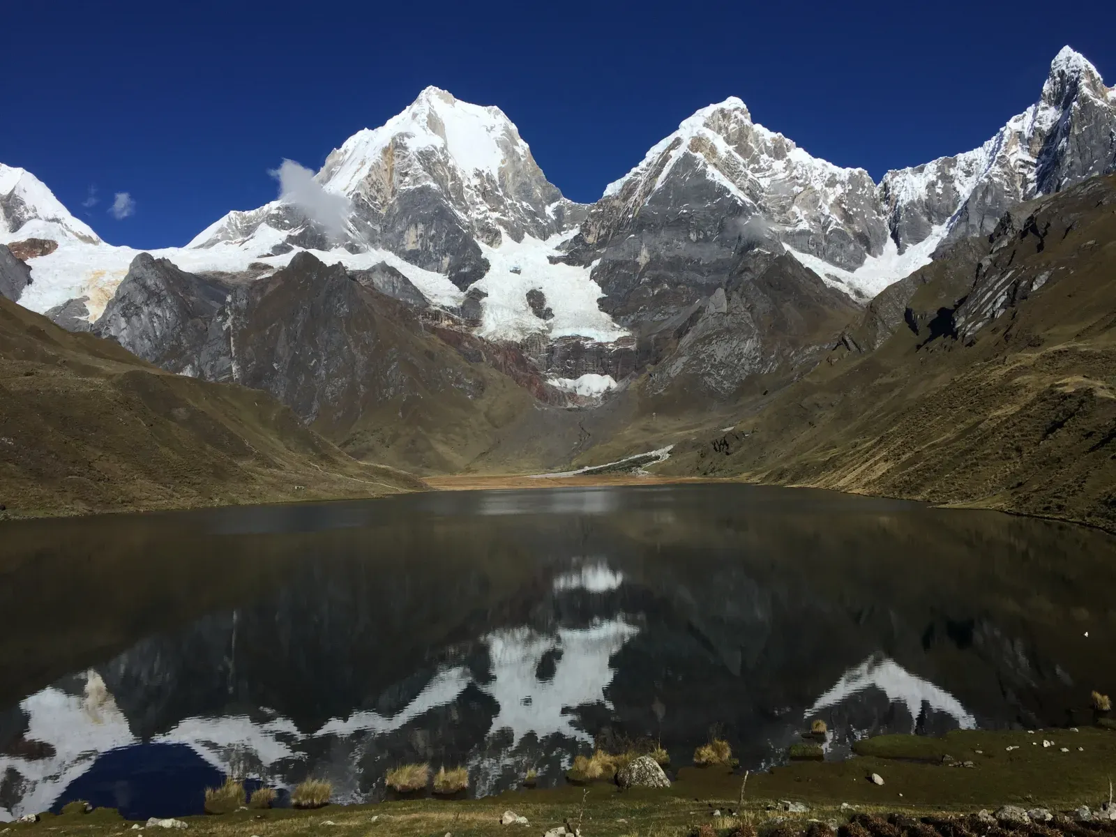 Snow peaks of the Cordillera Huayhuash reflected in a still laguna under a deep-blue sky