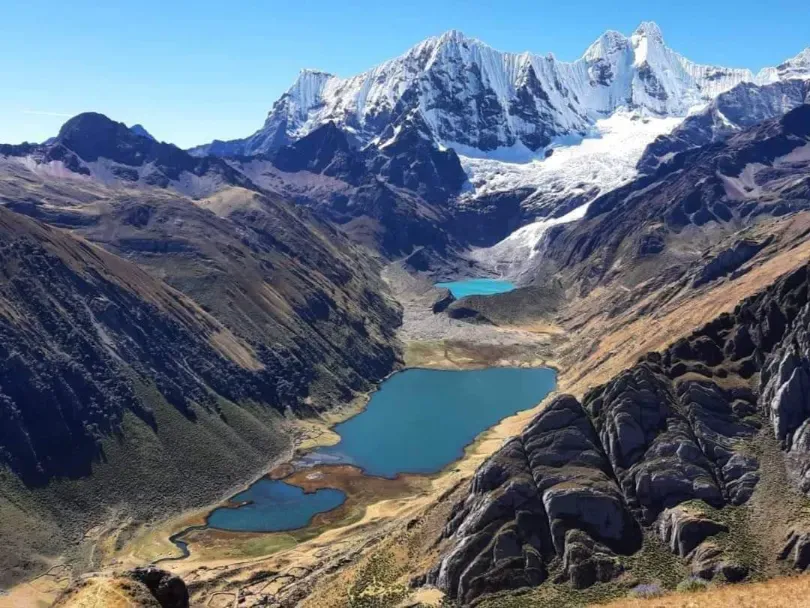 A chain of turquoise lakes in a glacial valley below the Huayhuash