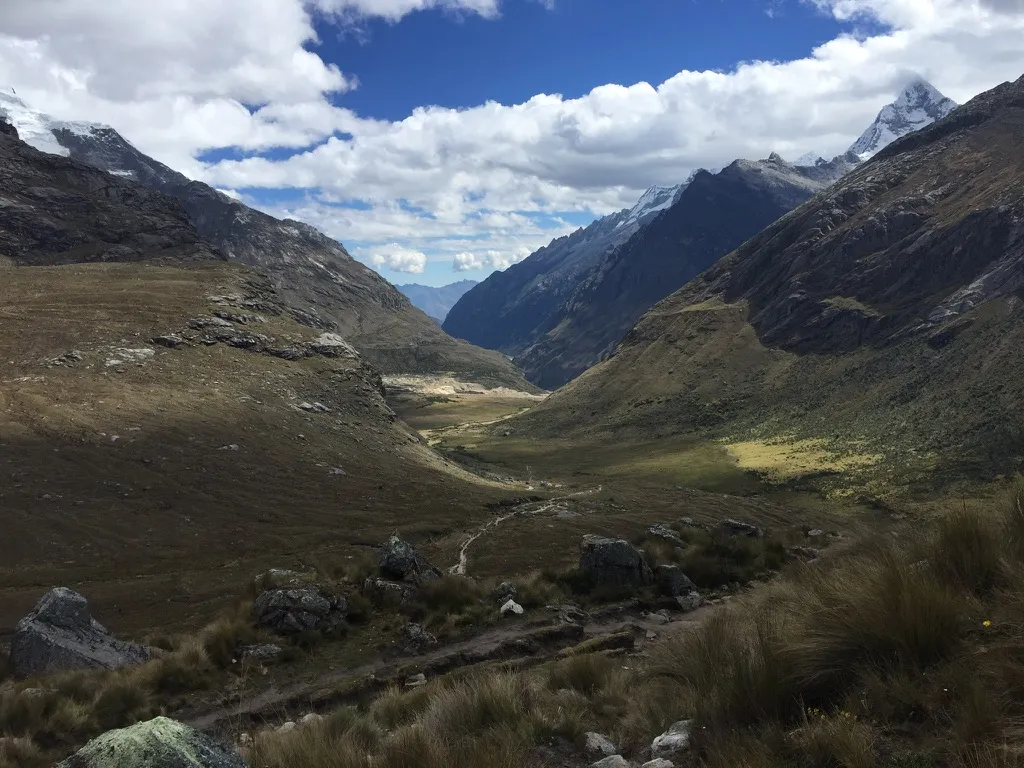 A stream winding through the Santa Cruz valley between rocky slopes and snow-covered peaks