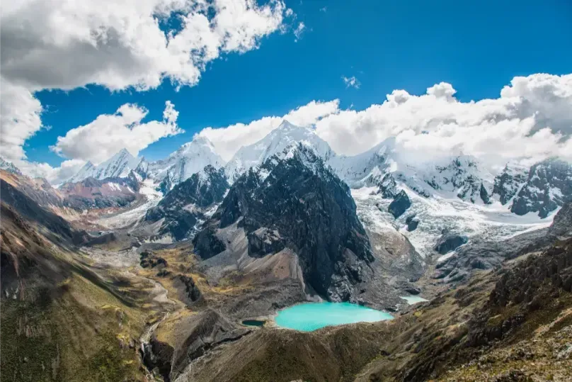 A turquoise glacial lake beneath the jagged peaks of the Huayhuash